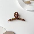 Detail of frosted leopard print hair claw clip with amber resin texture and gold spring - Cross Light Coffee