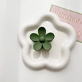 Detailed macro view of a matte forest green flower hair claw clip on a ceramic tray - Army Green