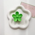 Close-up of matte green flower claw clip displayed on a white ceramic floral tray - Fruit Green
