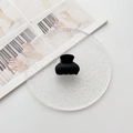 Dettaglio della piccola clip per capelli a semicerchio nero opaco su vassoio elegante - Nero
