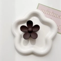 Detailed macro view of a matte dark brown flower hair claw clip on a white plate - Dark Coffee