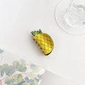 Primo piano di un simpatico fermaglio per capelli a forma di ananas su sfondo estivo - Ananas
