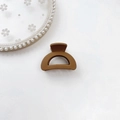 Detailed view of matte caramel hair claw clip on an elegant lace and pearl display plate - Plastic/Resin / Semi-circle-Ginger