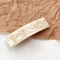 Detail view of square marble pattern hair clip with creamy shell finish and smooth texture - Marble Beige Yellow