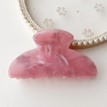 Close-up of pink marble pattern acetate hair claw on a white lace and pearl tray - Pink Marble