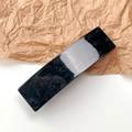 Close-up of elegant black acetate rectangular hair clip with marbled texture on paper - Quicksand Dark Grey