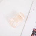 Close-up of peach hair claw clip with white polka dots and elegant infinity cross design - Jelly Light Orange