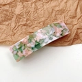 Detail of the elegant marble pattern on a rectangular acetate hair clip with pink and green - Marble Pink Green