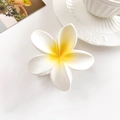 Detail van matte witte plumeria haarklem met geel centrum op een wit bureau - Melkgeel Verloop