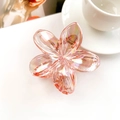 Close-up of peach pink flower hair claw with iridescent finish on white table - Iridescent Orange