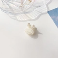 Macro di una molletta per capelli a forma di coniglio con perle su un vassoio di conchiglie - Plastica/Resina / Mini Pinza Perla - Coniglio