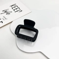 Detail shot of a matte black rectangular hair claw on a white decorative cloud tray - Matte Black