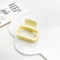 Detail view of a matte cream yellow square hollow hair claw clip on a white cloud tray - Matte Milk Yellow