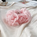 Detailansicht der zartrosa Chiffon Rose Haarklammer auf weißem Seidenstoff liegend - Rosa