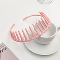 Detail of a pink matte non-slip headband with comb teeth leaning on a ceramic cup - Girl Pink