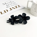 Détail de la pince à cheveux double fleur noir mat sur fond de bureau de style minimaliste - Double Fleur Mate - Noir