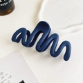 Detail of navy blue matte hair claw clip with wave design on a white ceramic tray - 11cm Wave / Matte Royal Blue