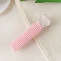 Detailopname van roze haarwortelclip met klittenbandtextuur op een gestructureerde stof - Kunststof / Roze