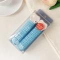 Detail of two blue self-adhesive hair rollers with clips in a transparent box - Plastic / Blue
