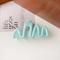 Detail view of light blue wavy hair claw clip on wooden block with aesthetic card - 11cm Wave / Glossy Lake Blue