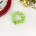 Detailed view of neon green satin scrunchie with smooth silk texture and natural folds - Fruit Green