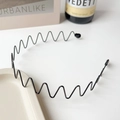 Détail d'un serre-tête ondulé en métal noir avec dents fines pour une fixation stable des cheveux - Serre-tête Noir - Grande Vague