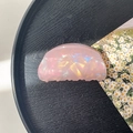 Macro detail of a pink iridescent shark hair clip on a black wood tray with daisy card - 8cm Round Head Claw Clip / Phantom Pink