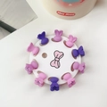 Nahaufnahme von zehn matten Mini-Haarklammern in Hasenform in Lila und Rosa auf Weiß - Violetter Hasen-Stil