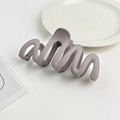 Detailed view of irregular wavy matte hair claw clip in elegant grey-purple finish - Plastic/Resin / Purple Grey