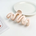 Detail shot of a matte light pink wavy hair claw clip on an elegant white ceramic plate - Plastic/Resin / Korean Pink