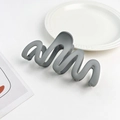 Macro shot of dark grey matte hair claw with wave texture on a decorative plate - Plastic/Resin / Blue Gray