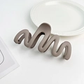 Detail view of the matte Morandi wave hair claw clip with a sleek S-shaped curve - Plastic/Resin / Mocha