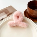 Gros plan d'une pince à cheveux en peluche rose doux sur une assiette en céramique blanche - 9cm Peluche Croisé - Blanc Neige