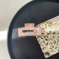 Close-up of a large iridescent pink marble resin claw clip on a stylish black tray - 7.5cm Rectangle Claw Clip / Phantom Orange