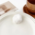 Détail en gros plan d'une pince à cheveux pompon en peluche blanche sur un plateau - Mini Rond Blanc (3cm)