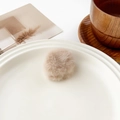 Vue détaillée d'une pince à cheveux en peluche beige doux sur une assiette décorative - Mini Rond Khaki (3cm)