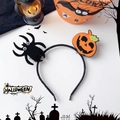 Detail view of Halloween headband with orange smiling pumpkin and fuzzy black spider decor - Pumpkin Spider Style