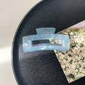 Close-up of a rectangular holographic blue hair claw clip on a dark wooden tray - 10.5cm Rectangle Claw Clip / Fantasy Blue