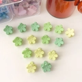 Primer plano de mini pinzas para el cabello con flores en colores menta y amarillo - Serie Verde Flor Pequeña