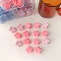 Detalle de mini pinzas para el cabello con flores en tonos rosa mate sobre fondo crema - Estilo Flor Rosa