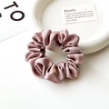 Dettaglio di un elastico per capelli in raso rosa antico con medaglietta dorata - Rosa