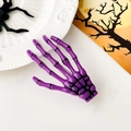 Dettaglio di un fermaglio per capelli a mano di scheletro viola su sfondo Halloween - Viola