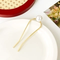 Épingle à cheveux dorée en U avec une grande perle blanche sur une assiette en céramique - Perle Unique Incurvée / Or
