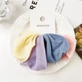 Detail of four colorful soft knitted hair ties on display card in a ceramic plate - Macarons