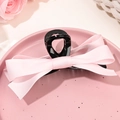 Dettaglio della molletta per capelli con fiocco in raso rosa e tessuto a doppio strato - Base Nera Rosa