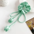 Dettaglio di uno scrunchie in raso verde menta con lunghi nastri e ciondoli a tulipano - Verde Lago Ciondolo Tulipano