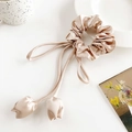 Dettaglio scrunchie in seta champagne con lunghi nastri e ciondoli a tulipano - Cachi Ciondolo Tulipano