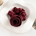 Détail macro du chouchou en satin rouge vin stylisé en rose sur une assiette décorative - Chouchou Satin Rose / Bordeaux