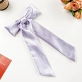 Detail of lavender satin ribbon bow hair clip with smooth silky texture and long tails - Purple