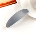 Gros plan sur la barrette ovale gris Morandi mat sur un bureau blanc élégant - Plastique/Résine / Gris Bleu